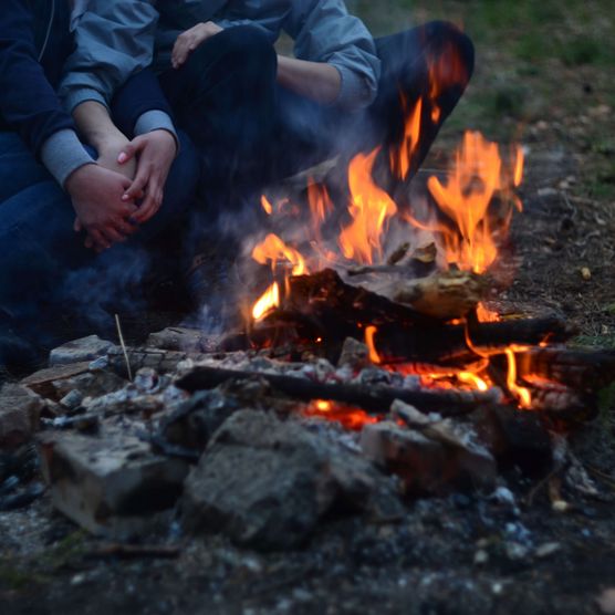 Foto Menschen sitzen gemütlich am Feuer - zum Foto