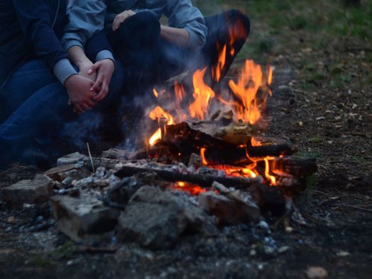 Foto Menschen sitzen gemütlich am Feuer - zum Foto