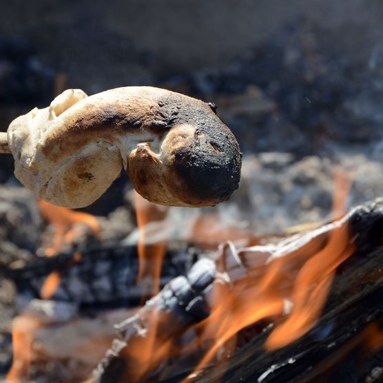 Foto Schlangenbrot am Stecken über dem Grillfeuer - zum Foto