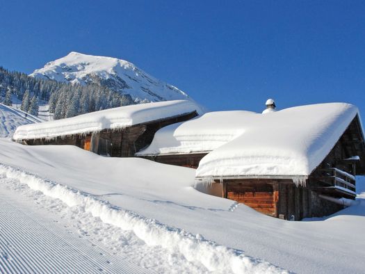 Foto Tief verschneite Alphütten - zum Foto