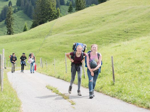 Foto Schüler wandern entlang einer Bergstrasse - zum Foto