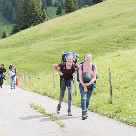 Foto Schüler wandern entlang einer Bergstrasse - zum Foto