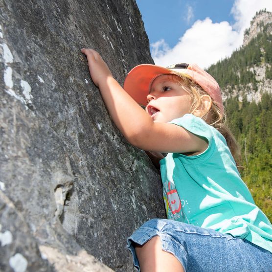 Photo Fillette grimpant sur un mur de pierre - voir la photo