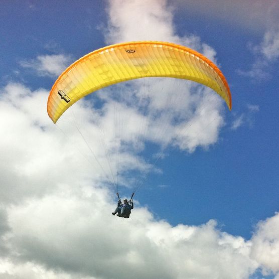 Foto Paraglider vor leicht bewölktem Himmel - zum Foto