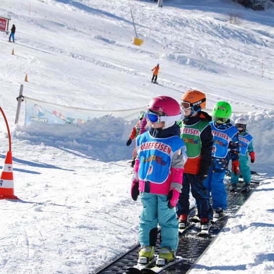 Photo Des enfants se tiennent sur un tapis magique et remontent la pente - voir la photo