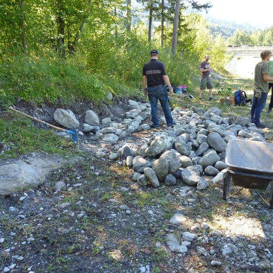 Foto Eine Gruppe von Freiwilligen schichtet Steine zu Steinlinsen - zum Foto