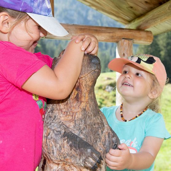 Picture Two girls are playing with a wooden marmot - to the picture