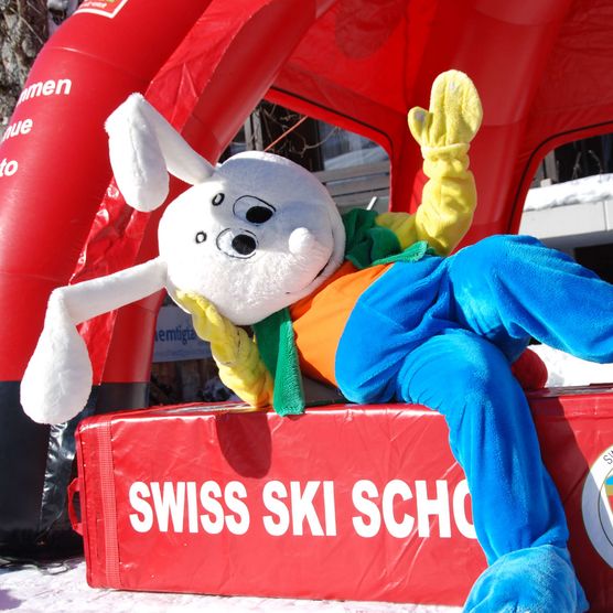 Photo La mascotte Snowli est assise sur un élément de la Swiss Ski School - voir la photo