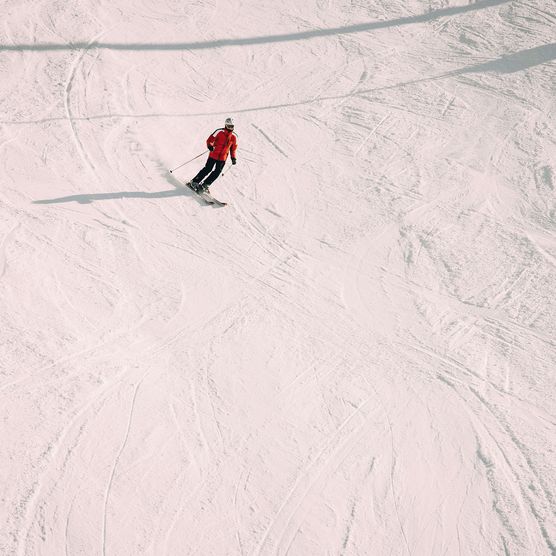 Foto einzelner Skifahrer auf Skipiste - zum Foto