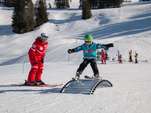 Foto Kinder fährt mit Ski über Hindernis - zum Foto